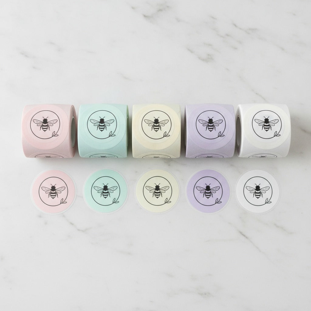 Flat lay of custom logo sticker rolls in pink, mint, yellow, lavender and white