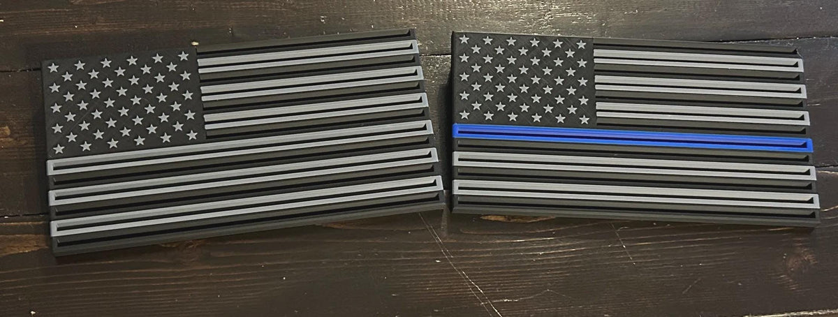 Thin Line Flag Challenge Coin Display pair in black and gray, one with a blue stripe, on dark wood