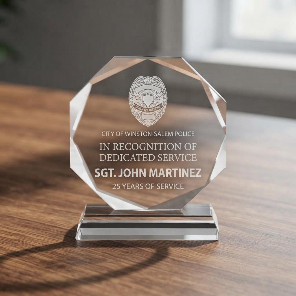 Personalized crystal award with police badge logo and "Sgt. John Martinez, 25 Years of Service" text on a wooden table