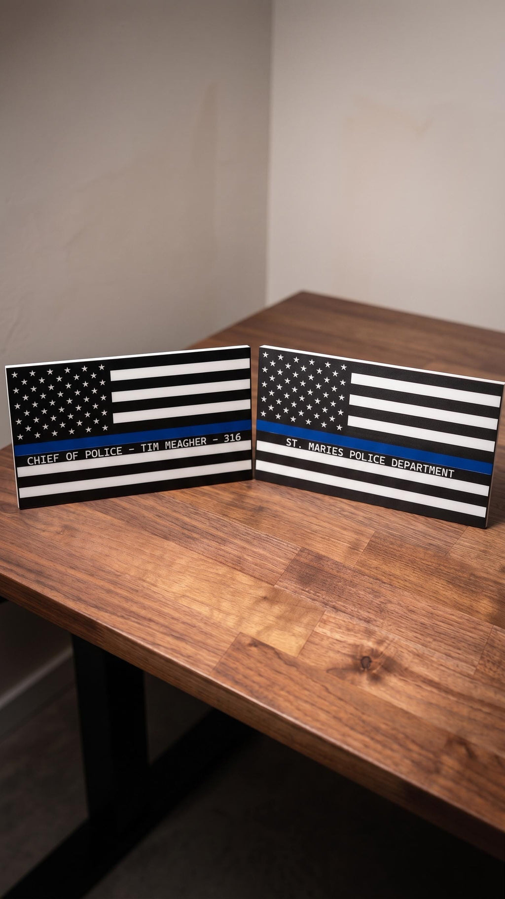 Personalized thin blue line flags: St. Maries Police Department and Chief of Police Tim Meagher 316, on wood table