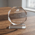 Personalized crystal award with Meridian Group logo, Employee Excellence Award text and Jane Anderson, on a wood table