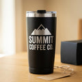 Black tumbler laser engraved with Summit Coffee Co. mountain logo, clear lid, on a wooden table near a gift box